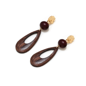 Detail of vintage geometric earrings with hollow wooden teardrop and metal accents