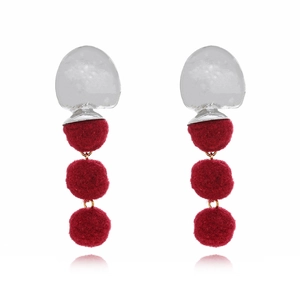 Three-tier red pom-pom drop earrings with silver geometric accents on white background