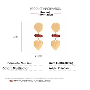 Detail view of heart drop earrings with dimensions of 7cm length and 2.3cm width on white