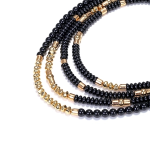 Close-up of bohemian multilayer necklace with black beads and gold metallic accents
