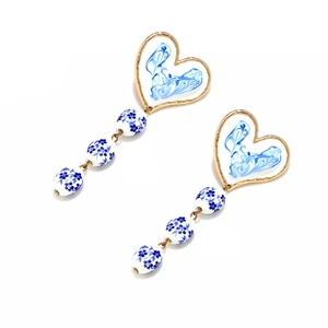 Handmade heart-shaped enamel drop earrings with blue floral ceramic beads and gold frames
