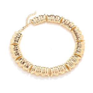 Detailed view of chunky gold metal choker featuring unique vertical pleated texture