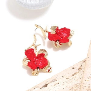 Dettaglio degli orecchini a rosa in smalto rosso con petali dorati su base di pietra