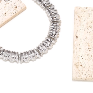 Detailed macro view of chunky silver modular necklace with textured ripple metal finish