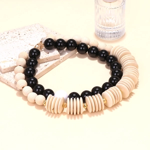 Handmade geometric wooden bead necklace featuring black and beige stacked resin accents