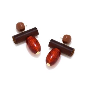 Macro detail of retro resin drop earrings with wood textures and amber translucent finish