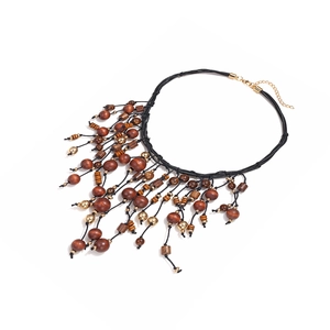 Collier bohème en perles de bois nouées avec sphères dorées et pendentifs glands
