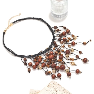 Détail du collier à franges bohème avec perles en bois et accents dorés