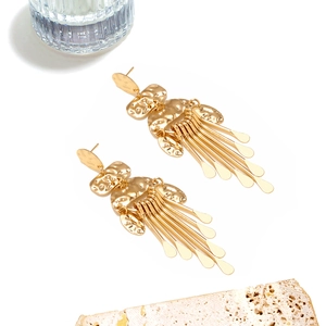Detail of gold geometric tassel earrings with hammered texture finish for women