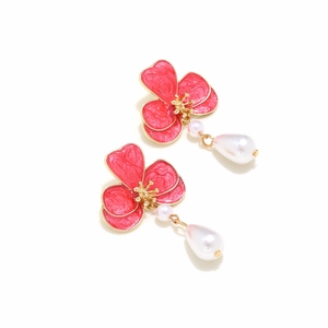 Detail of vintage red enamel flower earrings with elegant white teardrop pearl pendants