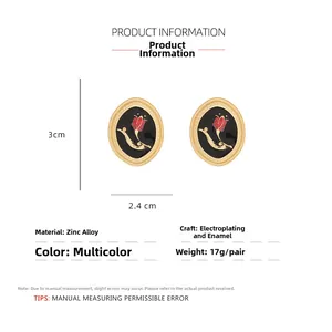 Detail view of retro oval rose earrings with gold finish and enamel floral patterns