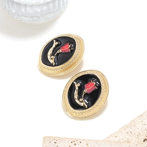 Vintage gold oval stud earrings with red enamel rose detail on black background