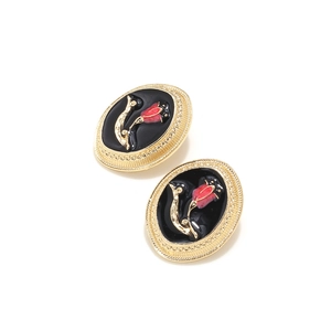 Detail of vintage oval earrings with red tulip enamel pattern and golden floral borders