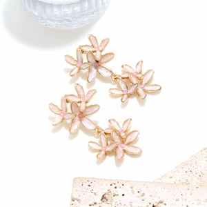 Détail de boucles d'oreilles fleurs 3D en émail faites main avec pétales roses et or