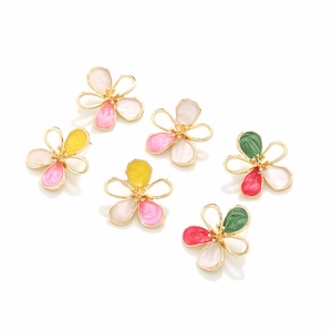 Detailed macro view of six colorful enamel flower earrings with gold hollowed frames
