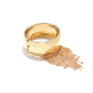 Detail of golden hammered metal cuff bracelet with delicate hanging fringe tassels
