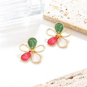 Macro shot of colorful enamel flower earrings with hollow gold edges and marble texture