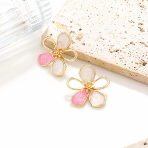 Detailed close-up of gradient pink enamel flower earrings with golden core on stone base