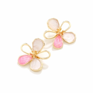 Macro view of gold flower earrings with pink and white gradient enamel petals