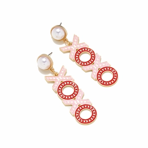 Detailed view of XOXO letter drop earrings with pink enamel and pearl accents