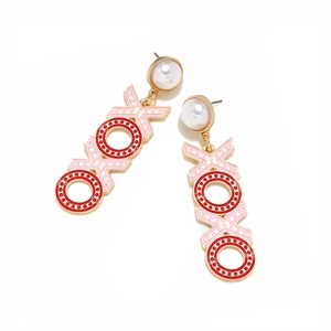 Detail of gold-plated XOXO drop earrings with pink and red enamel and faux pearls