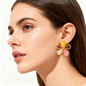 Chic hollow gradient enamel flower earrings in yellow and pink on model's ear