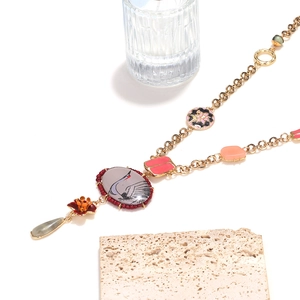 Macro shot of vintage necklace with painted crane pendant and colorful beads detail