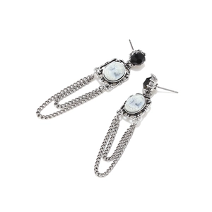 Detail of vintage silver earrings featuring cameo portrait and long fringe chains