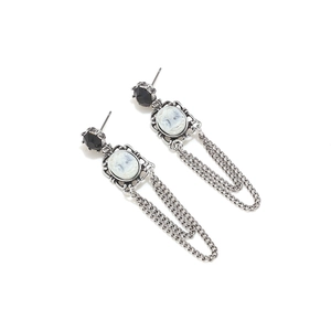 Macro detail of vintage silver drop earrings with portrait cameo and metal tassels