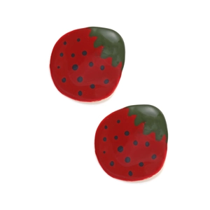 Gros plan des boucles d'oreilles fraises émaillées avec glaçage rouge et feuilles