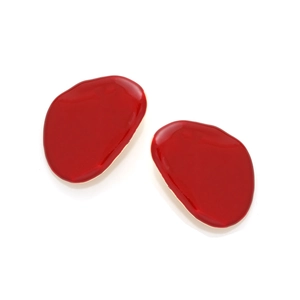 Detailed view of red enamel glaze and golden irregular geometric stud earrings