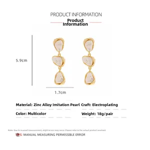 Detail view of Baroque pearl drop earrings with 5.9cm height and 1.7cm width dimensions