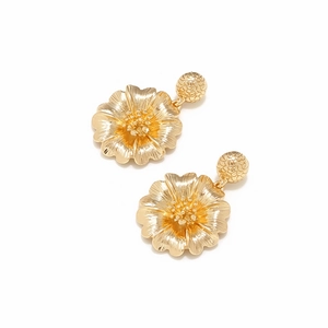 Nahaufnahme goldener Blumenohrringe mit detaillierten Texturen und metallischen Perlen