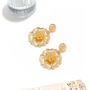 Detailansicht goldene Blumenohrringe mit gebürsteter Metallstruktur und Blütenblättern
