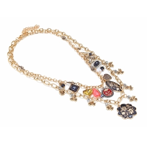 Detail showing vintage gold layered necklace with black enamel flower and heart pendants