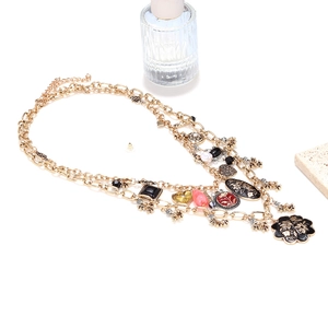 Layered gold necklace featuring vintage enamel heart pendants and floral charms