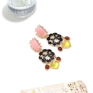 Vue détaillée des boucles d'oreilles vintage avec pierre en résine rose et émail floral