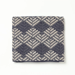 Detail of navy and beige geometric jacquard knit pattern on thick winter scarf