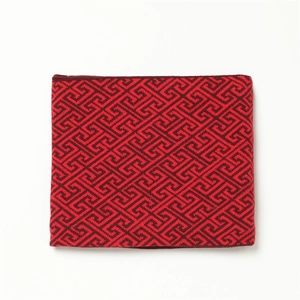 Nahaufnahme eines roten Strickschals mit traditionellem geometrischem Muster und Textur