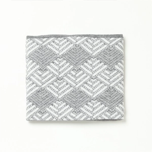 Detailed view of gray and white knit neck warmer with geometric diamond pattern