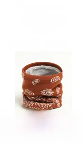 Détail d'un cache-cou en tricot d'hiver avec motif paisley marron et doublure en polaire