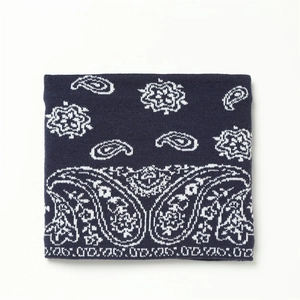 Détail macro du cache-cou en tricot bleu marine avec motif paisley jacquard blanc