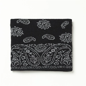 Gros plan d'un tour de cou en tricot épais avec motif paisley gris sur tissu noir