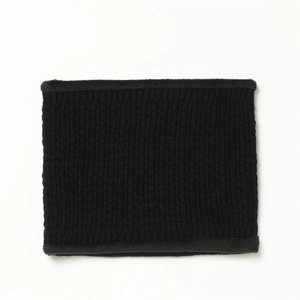 Detail of black knitted neck warmer with plush fur lining and vertical ribbed texture