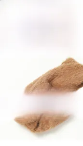 Détail de l'écharpe en fausse fourrure marron montrant le design noué et la texture douce