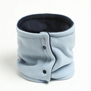 Close-up of light blue knitted neck warmer with black snap buttons and thick fleece lining