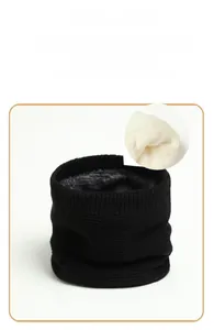 Detail of black knitted neck warmer featuring soft white plush lining and fine texture