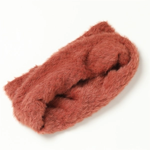 Détail d'un tour de cou en fausse fourrure de lapin rouge brique avec texture pelucheuse