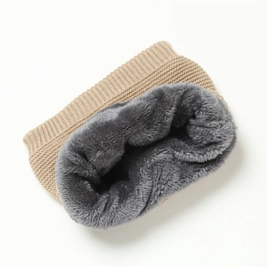 Close-up of winter neck warmer with beige knit texture and thick grey faux fur lining