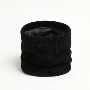 Detailed close-up of winter neck warmer with soft grey plush lining and black knit texture